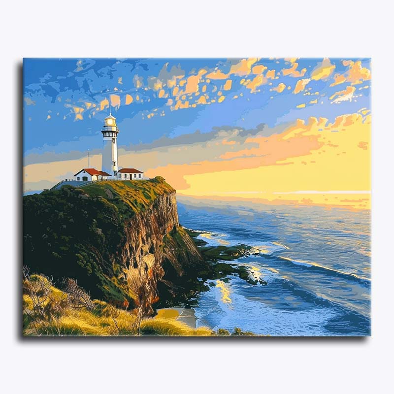 Paint by numbers artwork of a white lighthouse on a sea cliff at sunset, overlooking golden ocean waves and a glowing sky.