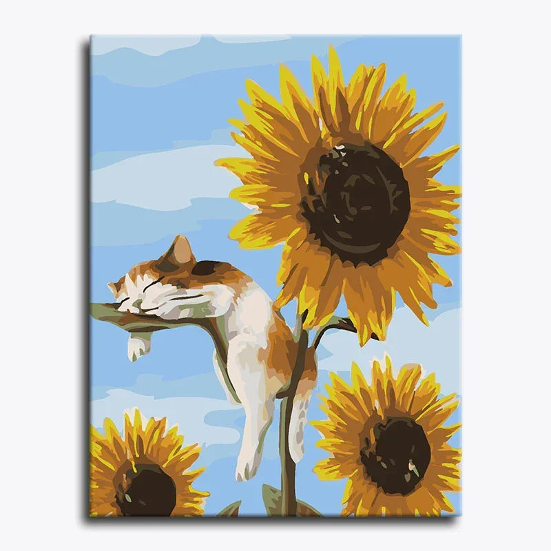 Canvas print with a cat sleeping on a sunflower against a blue sky.