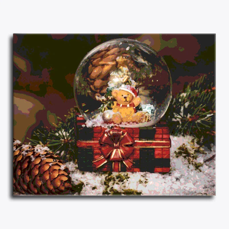 Christmas-themed snow globe with a teddy bear and lights, surrounded by pine cones and branches.