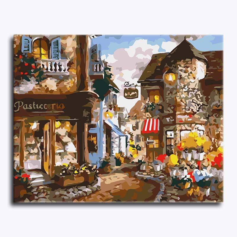 Painting of a quaint European street with shops and flowers