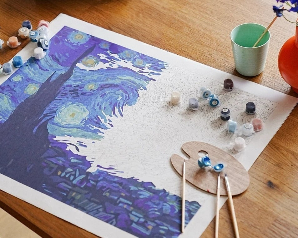 Paint by numbers canvas in progress with paints and brushes