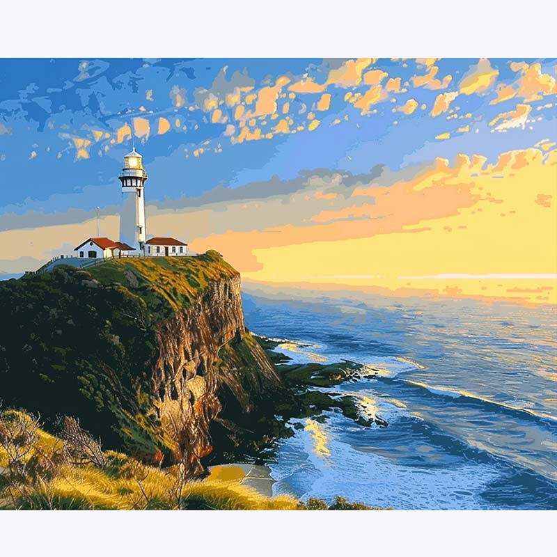 Lighthouse on a cliff overlooking the ocean with a colorful sky.