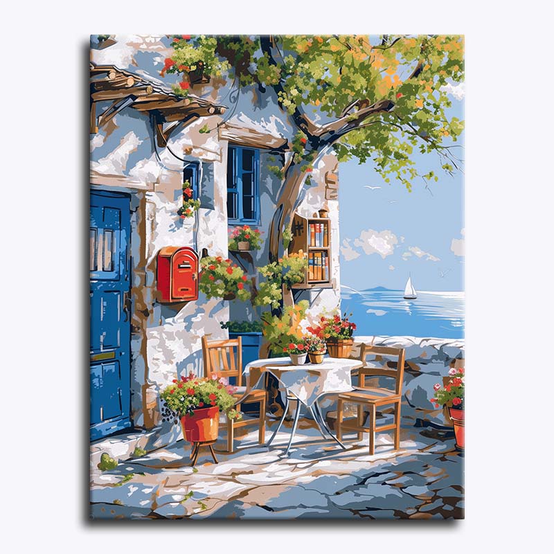 Painting of a coastal scene with a table, chairs, and flowers by the sea.